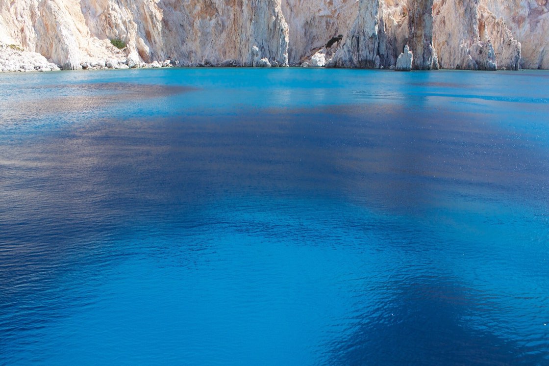 The electric-blue water and pale cliffs of Polyaigos